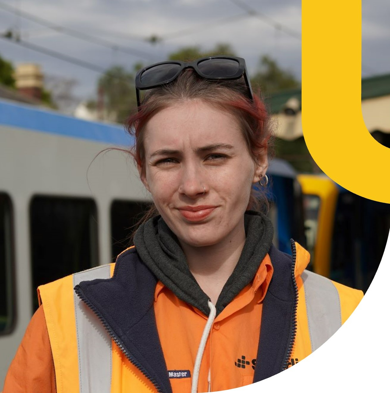 Woman in high visibility clothing on railway platform