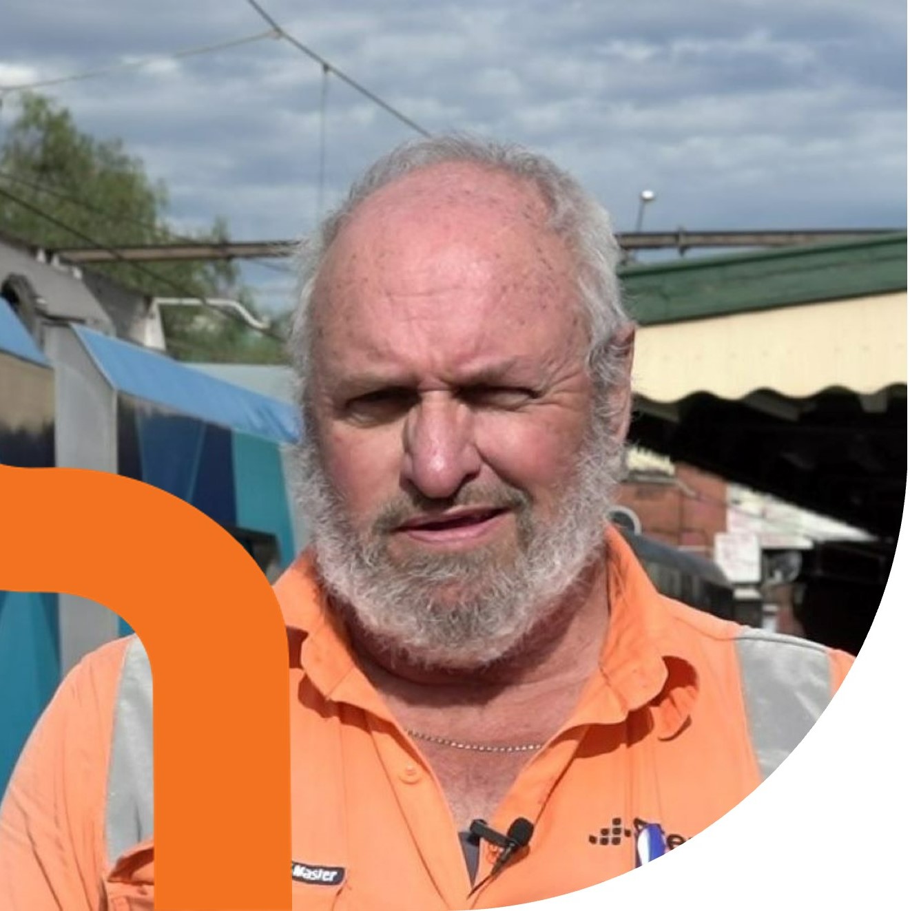 Smiling man in high visibility clothing on railway platform