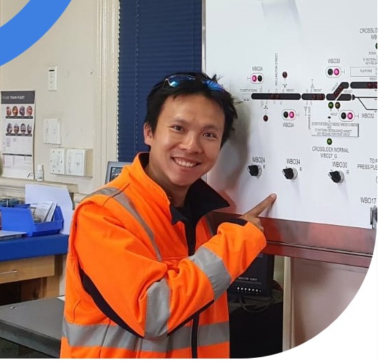 Man wearing high visibility working on a rail systems board
