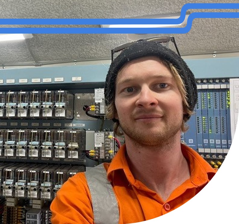 Male signalling technician standing in front of electrical unit