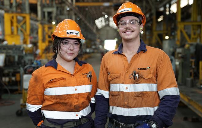 Man and woman in dirty overalls and hard hats in train depot