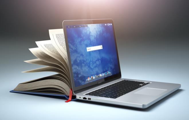 Photo of book and laptop to represent digital courseware for rail training programs