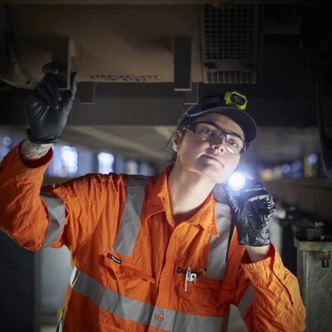 Worker inspecting under the train