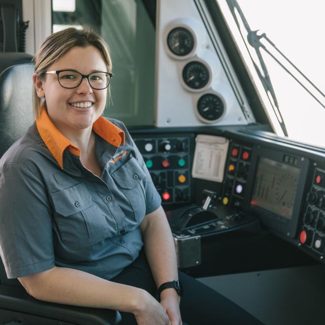 Female train driver sitting at controls