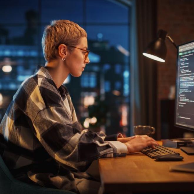 Female programmer working at home at night.
